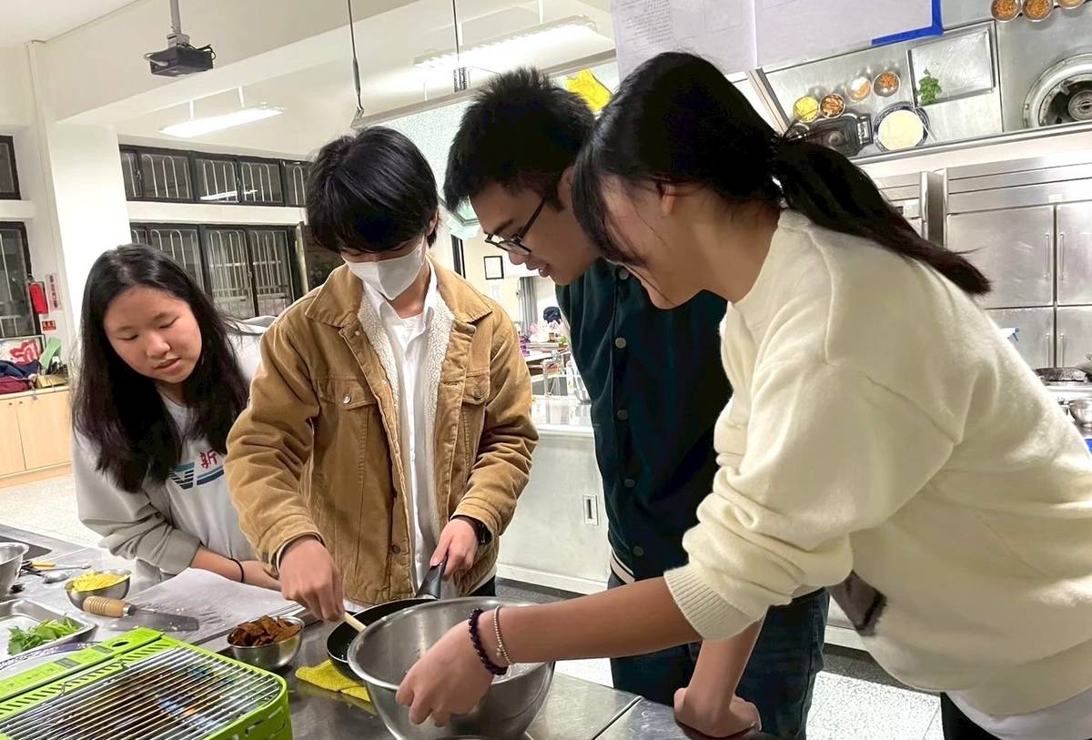 新店高中與越南國際生Joe(右二)於料理體驗課製作潤餅