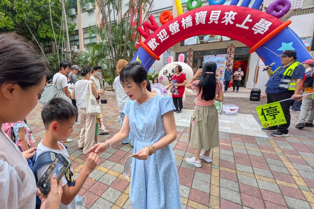 校長莊訪祺在校門口迎接學生上課