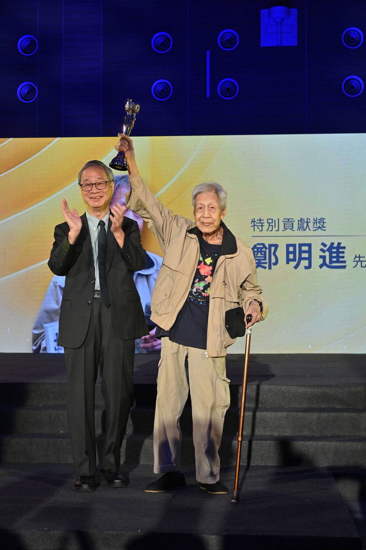 李遠部長（左）頒發特別貢獻獎給資深兒童文學家鄭明進（右）。