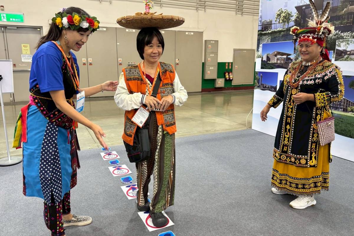 現場參觀民眾穿上原住民背心、頭頂著篩子、玩著另類的跳房子遊戲，歡樂體驗頂小米活動。