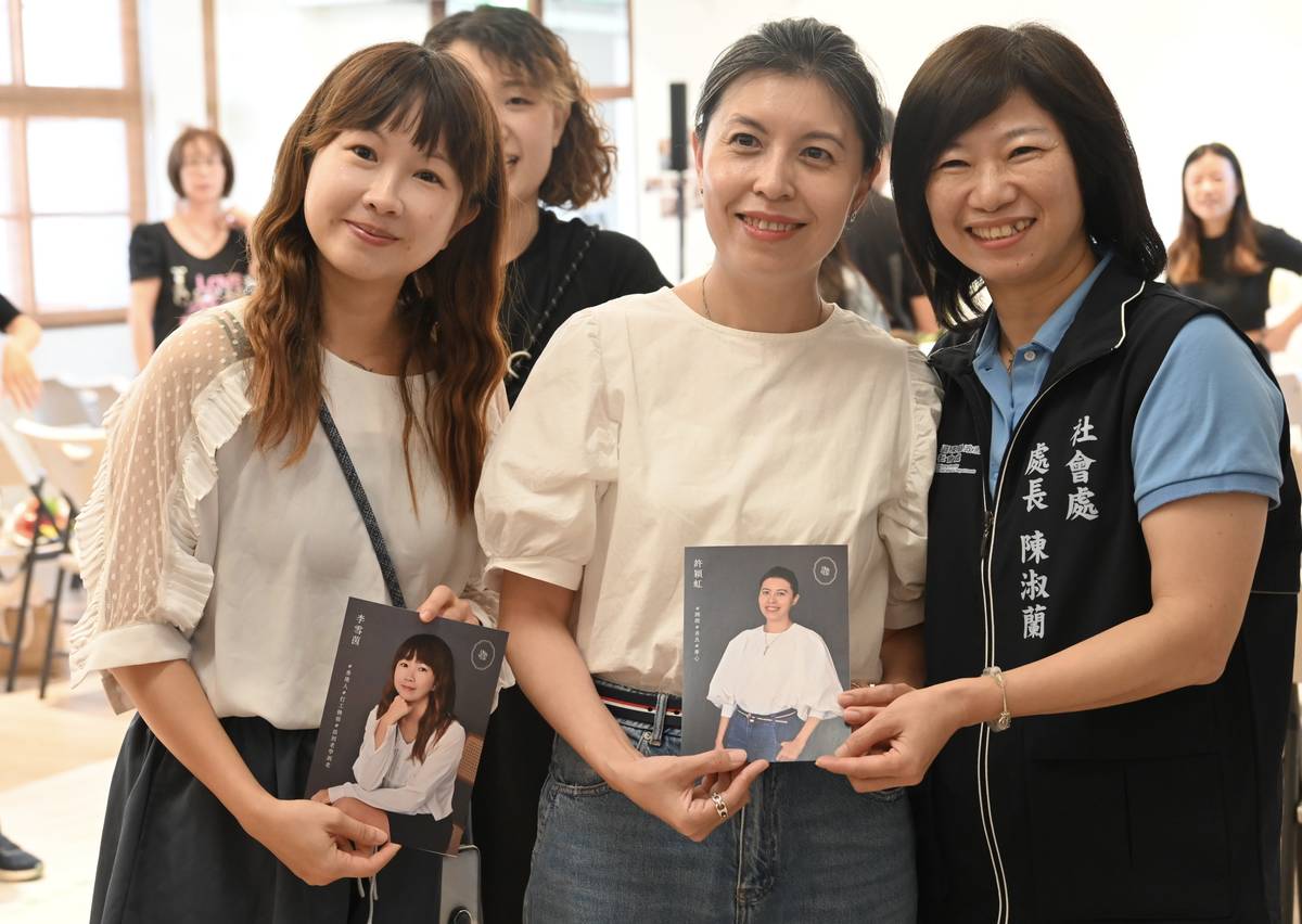 參與東工坊的成員，拿著自己的照片做成的專屬卡片，與縣府社會處陳淑蘭處長合影留念。