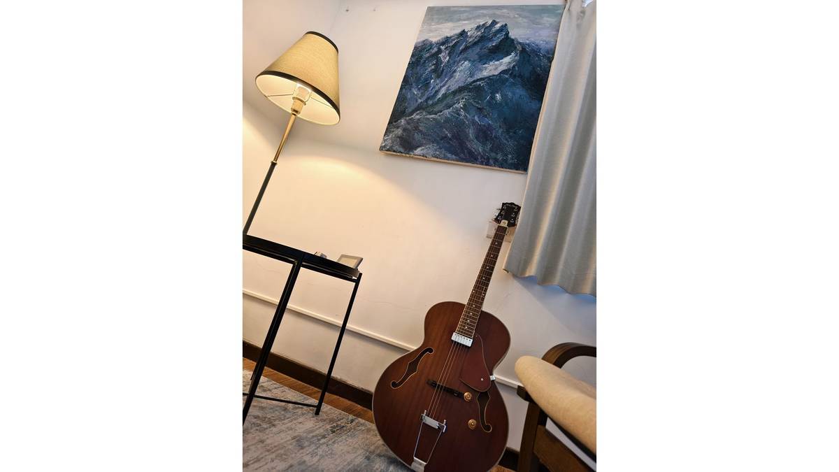牆上玉山油畫與爵士吉他。油畫由導演高子甯的母親所繪製。