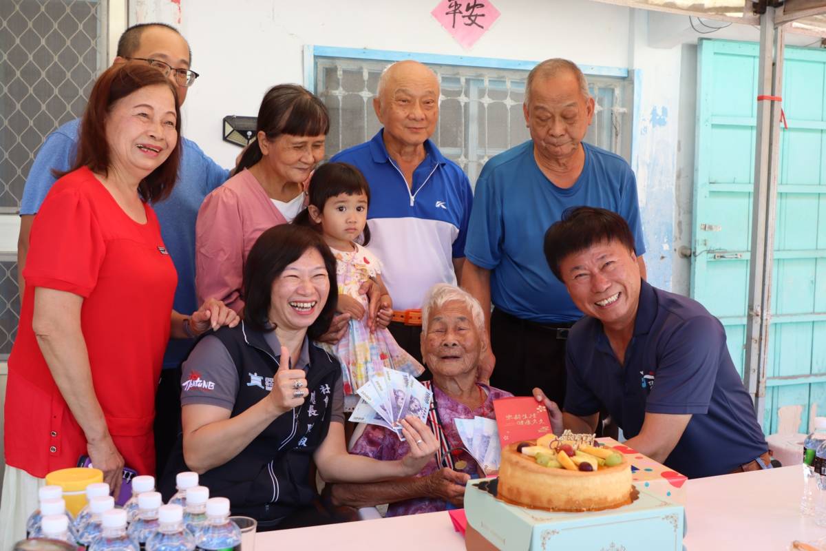 陳市長和縣政府社會處陳處長送重陽節禮物給市區的人瑞王陳怨女士，同時與其家人開心的合照。
