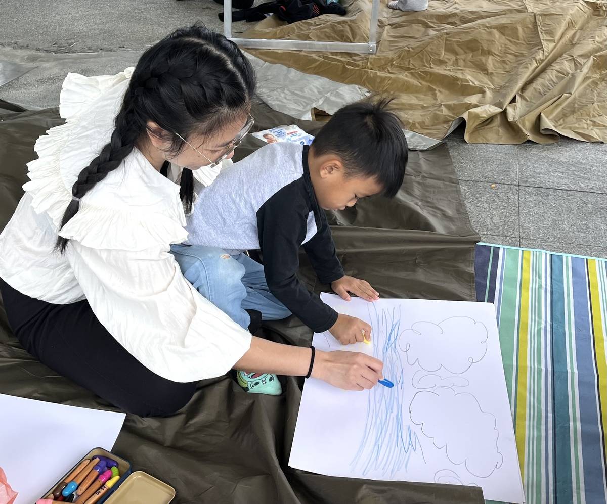 有許多家長陪著小朋友前往國際地標，參加全國寫生日活動。