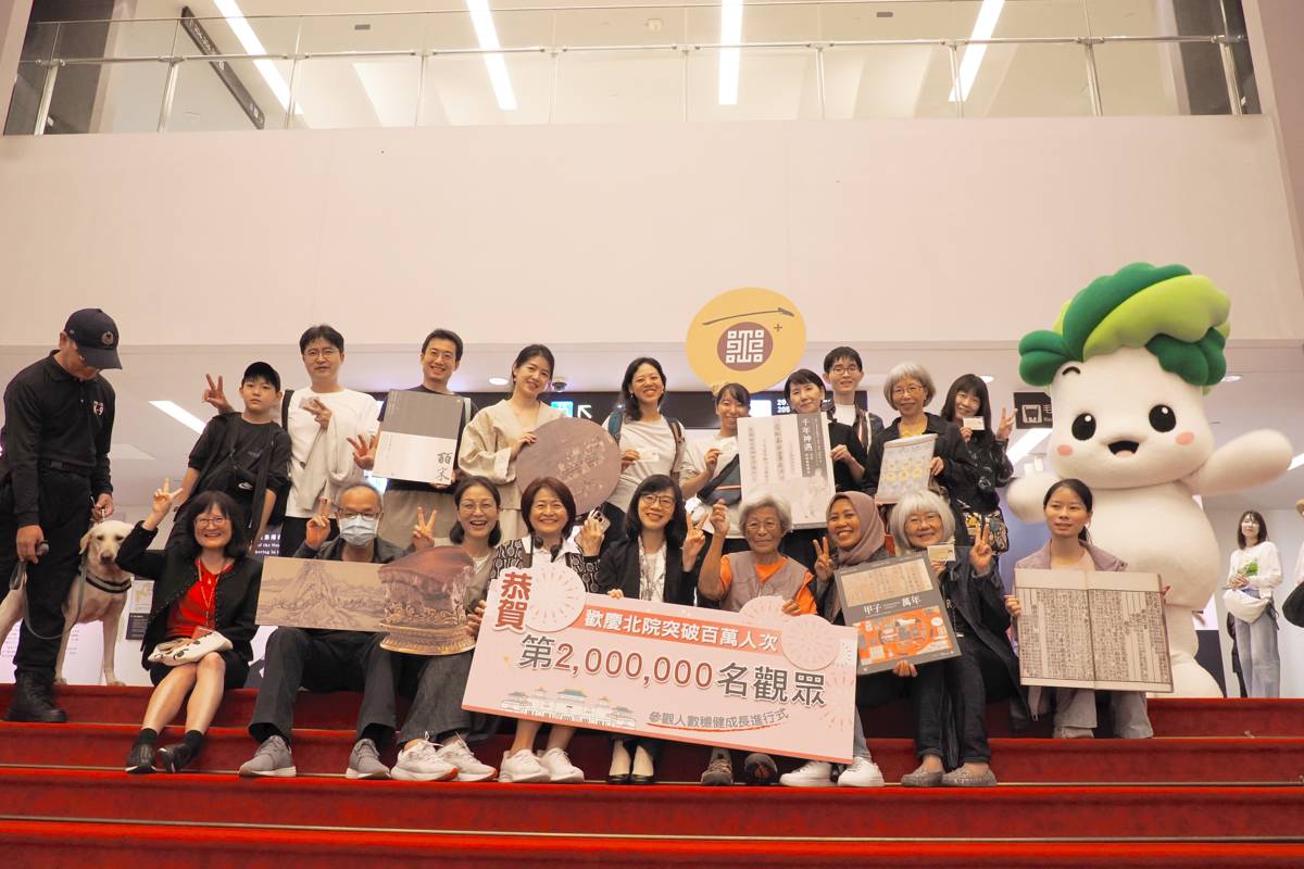 故宮余佩瑾副院長與吉祥物小翠、國寶犬在第一展覽館大廳歡迎第1,999,995名至第2,000,005名觀眾的到訪。（故宮提供）