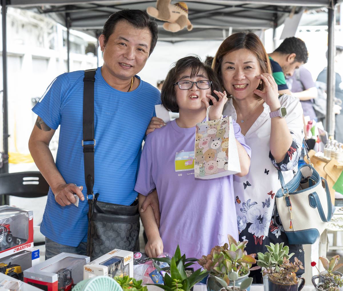 家長陪同學生於市集攤位選購商品，在互動中培養生活能力與自主表達