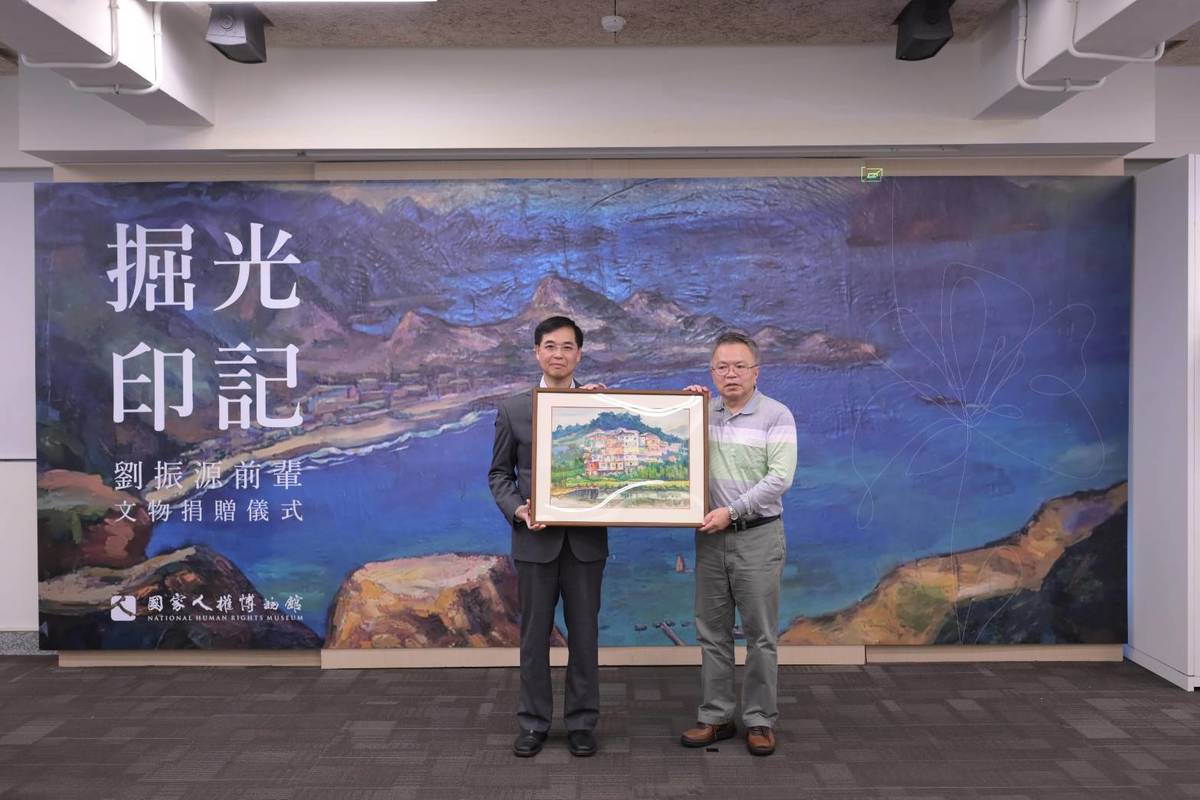 劉振源前輩家屬劉介光先生(右)代表將文物捐贈予人權館，由人權館館長洪世芳接受。(人權館提供)