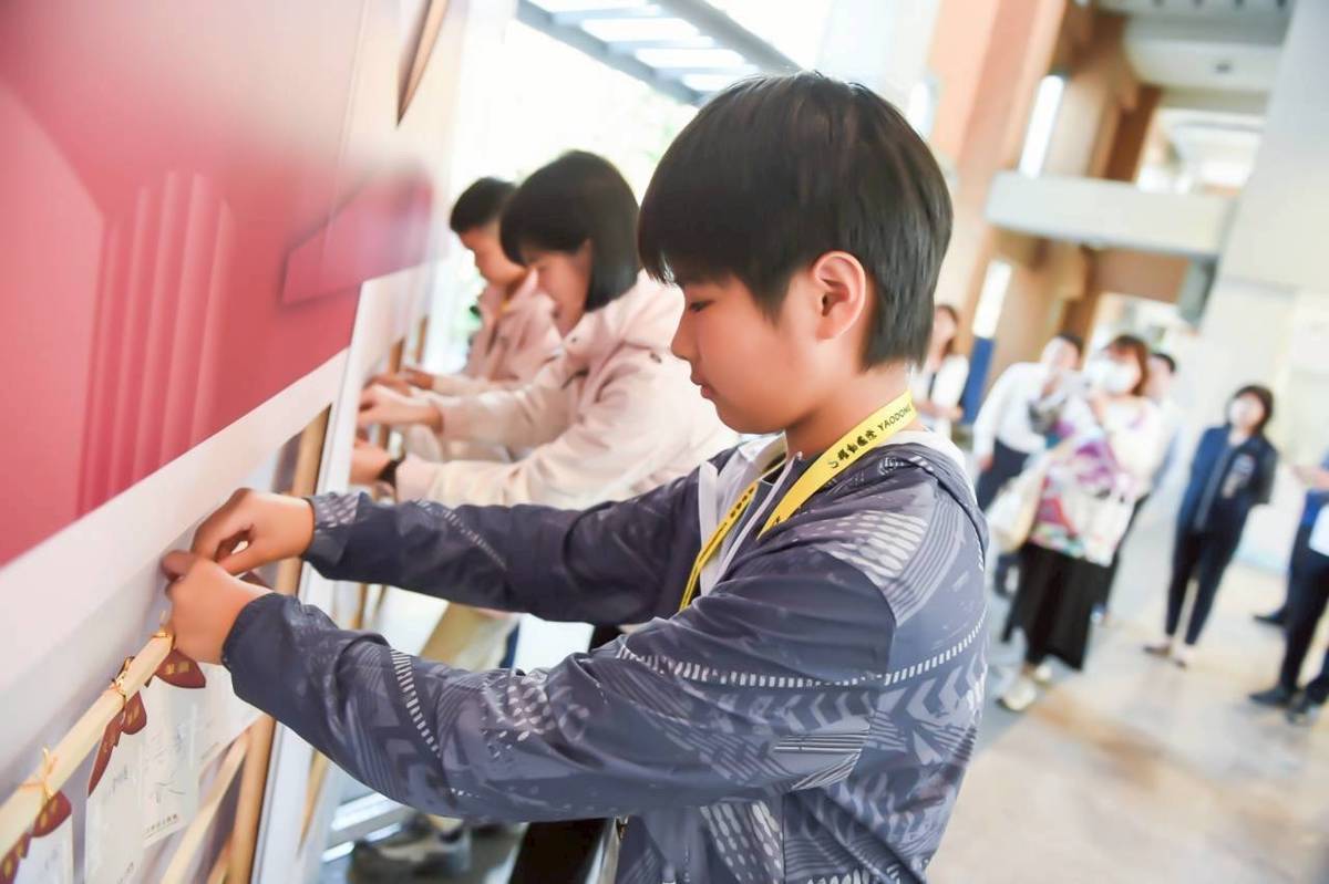 競賽員在許願祈福區掛祈願卡 (教育部提供)