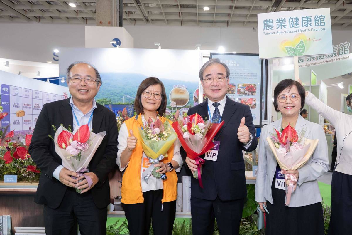 農業部次長胡忠一（右二）、農業科技司李紅曦司長（右一）與高雄場同仁及火鶴花束合影(圖片：農業部提供)