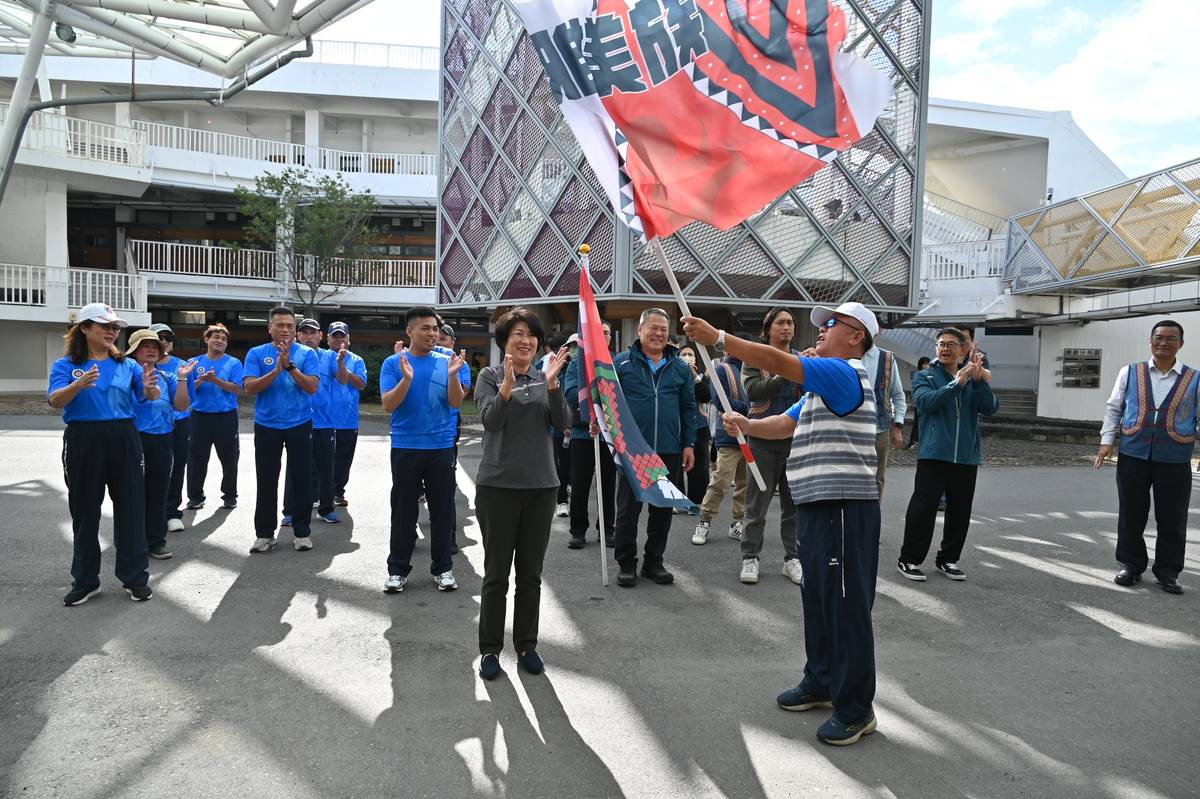 雅美隊隊長黃光道從饒縣長手中接下旗幟揮舞，並與選手高喊三聲「臺東縣！加油」、「原住民！出力」。