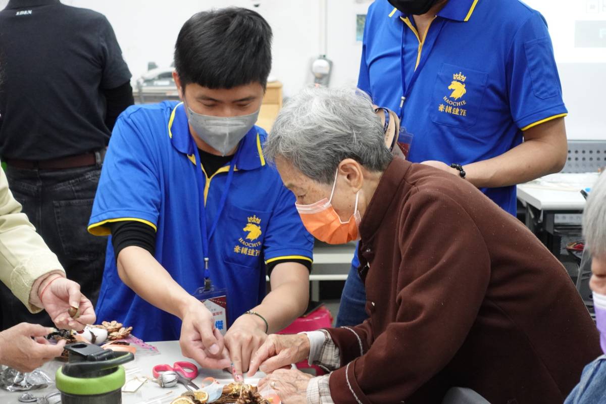 豪棋建設號召數位員工及住戶加入志工行列，陪伴長輩手作聖誕花圈