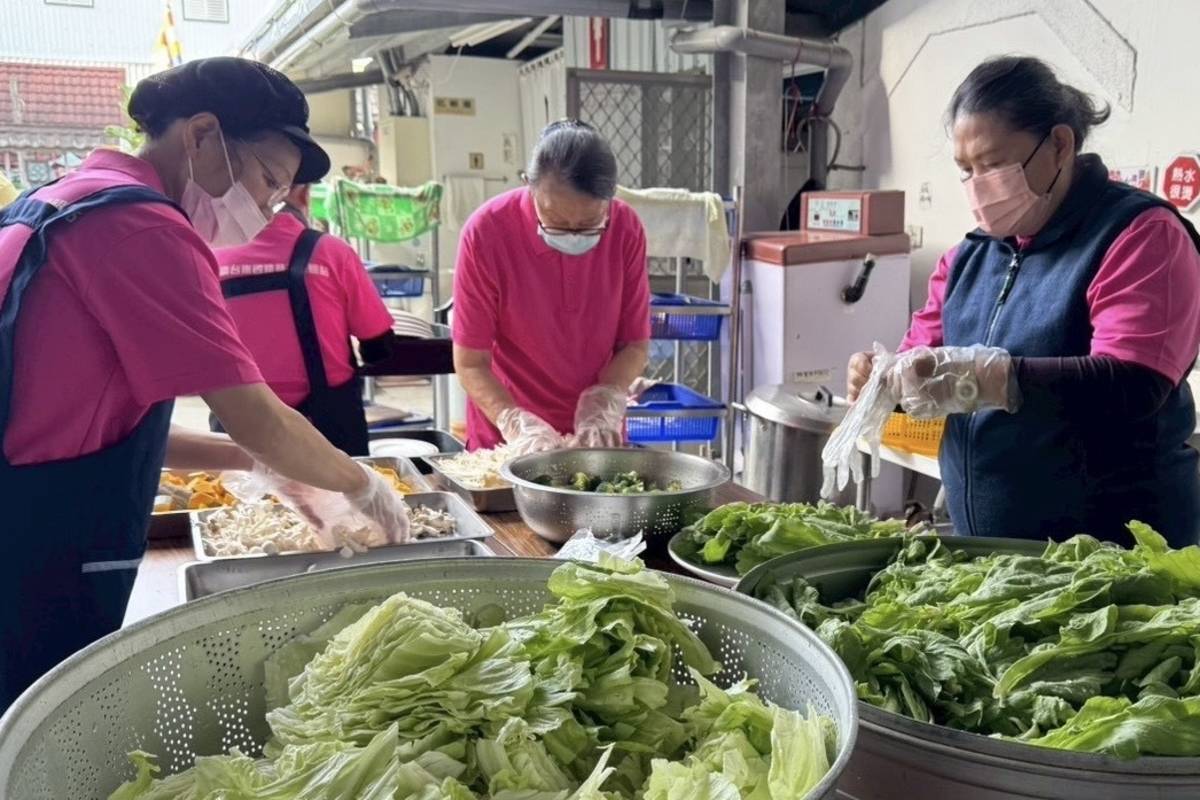 志工們一早便投入準備工作，洗菜、切菜、備料分工有序。