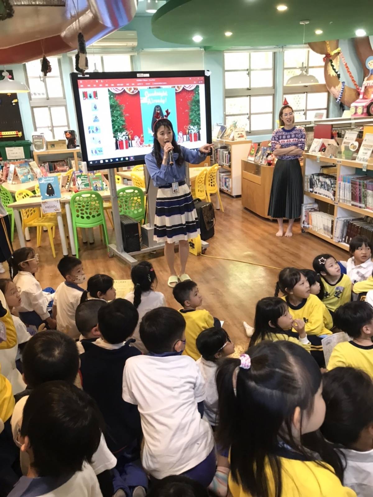 校長和學生在圖書館內聽志工說故事