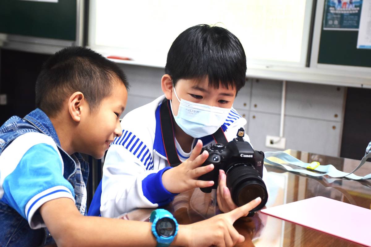學生充滿好奇專注於相機操作體驗，學習攝影樂趣