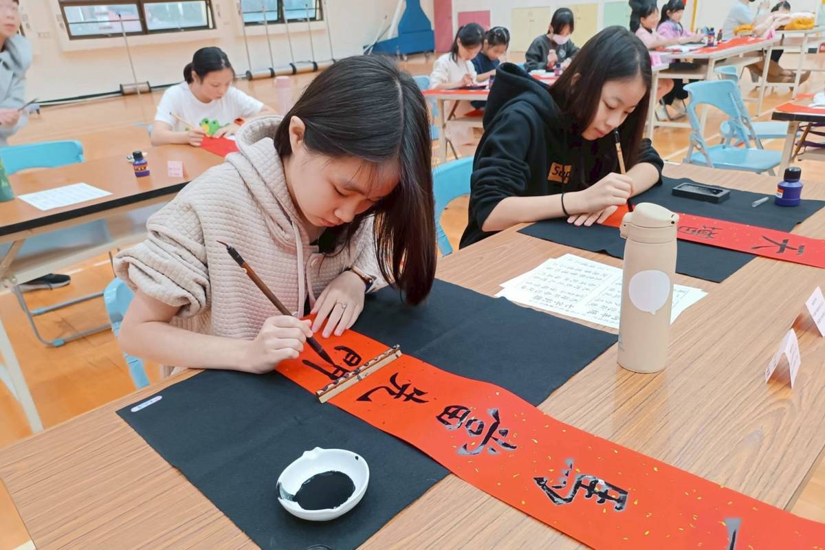 臺北市西園國小舉辦「躍馬奔騰迎新歲」迎春活動，孩子動筆寫春聯

