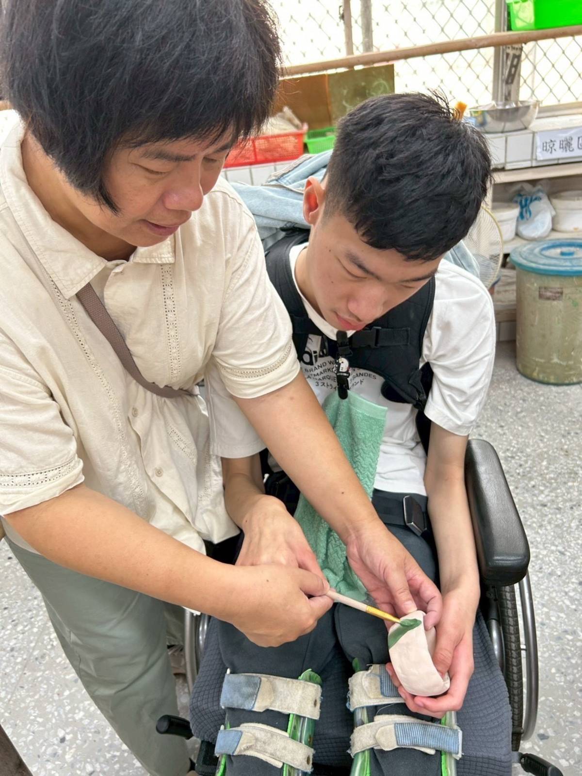 特教助理員林細澤協助學生彩繪陶土