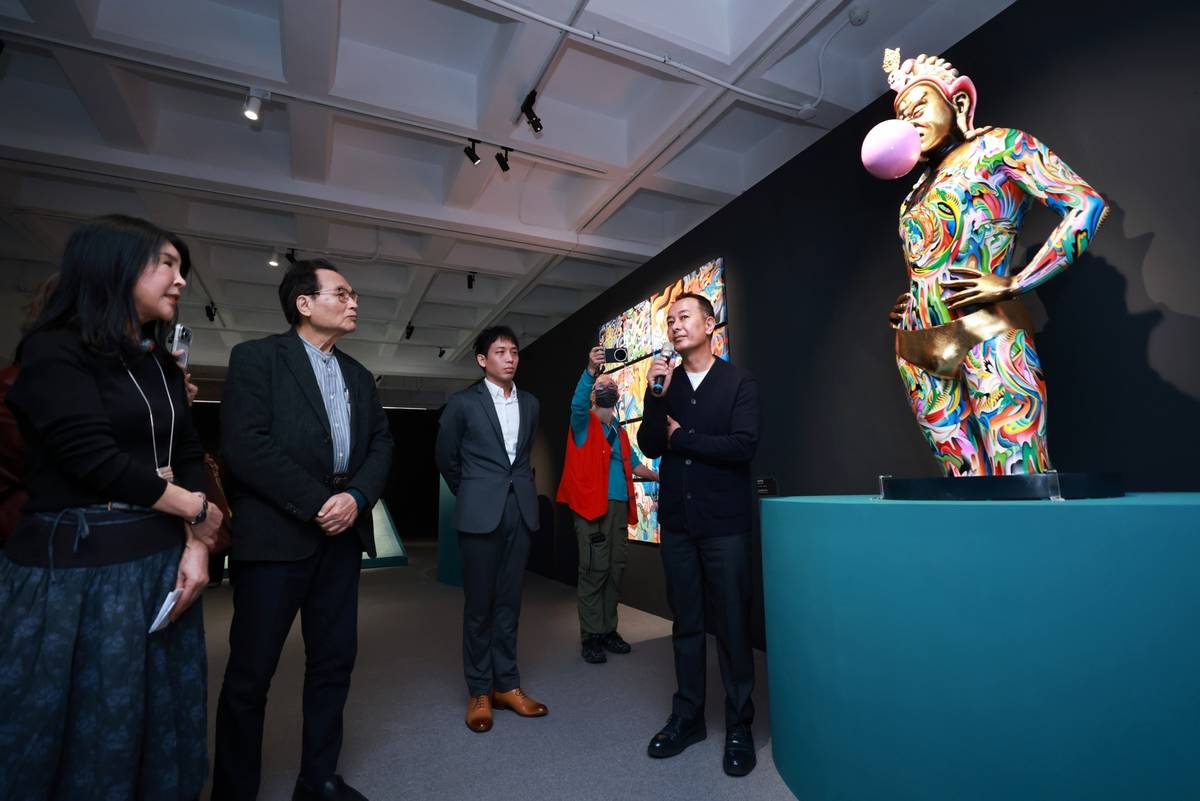 藝術家才仁・夏爾帕（Tsherin Sherpa，右）介紹雕塑作品 《隊長—崛起》