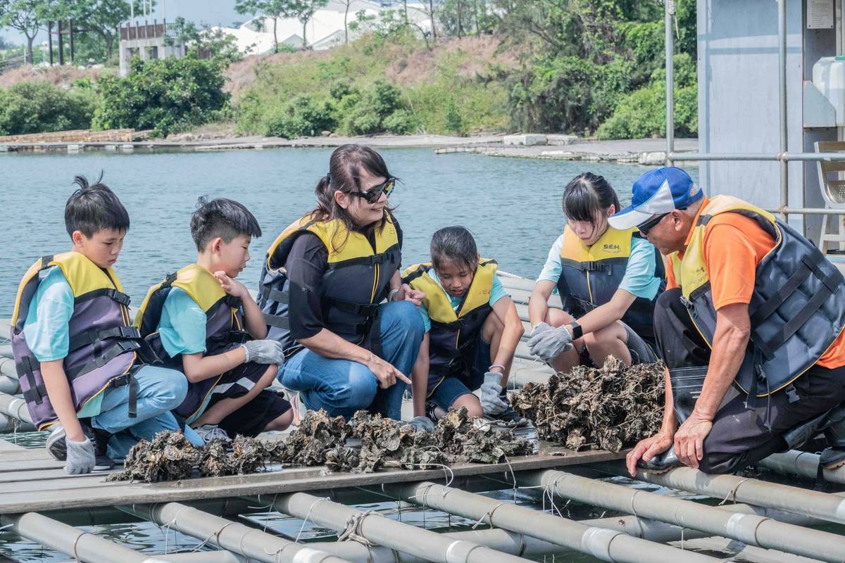 邱馨慧（左三）親自帶孩子到海邊觀察牡蠣的養殖 (教育部提供)